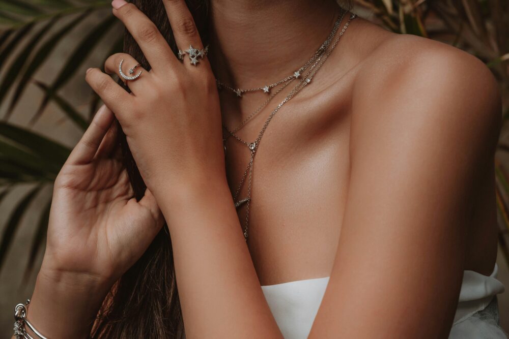 Minimalistic stacked silver necklaces and rings displayed together