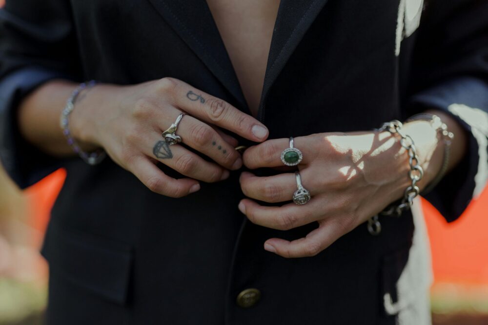 Edgy silver rings and bracelets arranged on a hand with tattoos