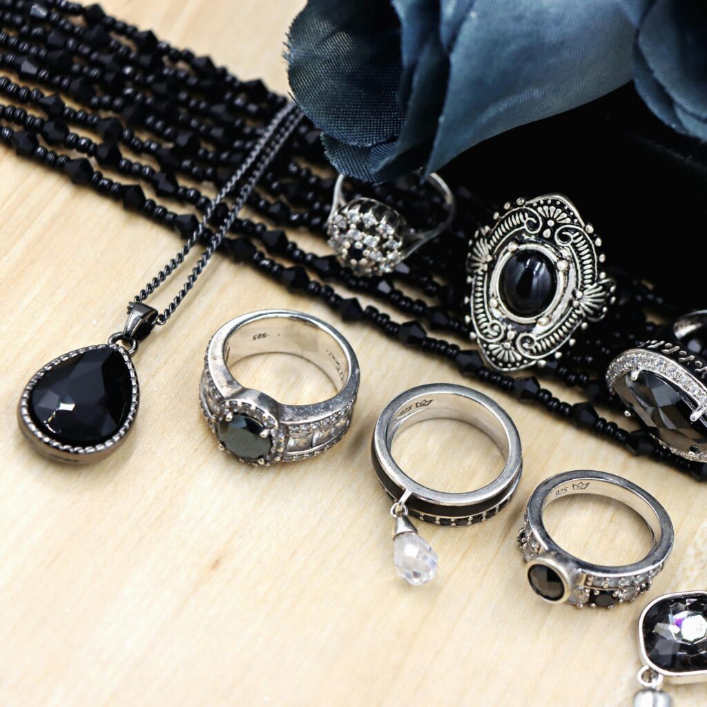 Gothic silver rings and bracelets arranged neatly on a flat surface.