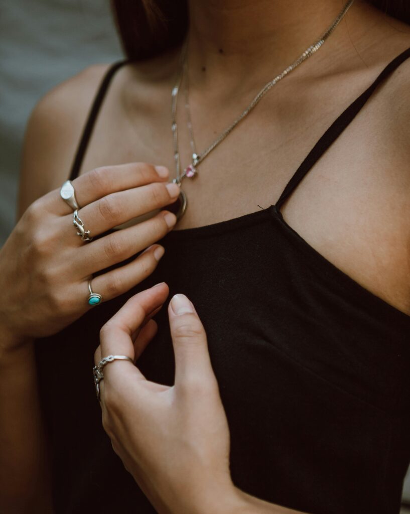 minimal silver jewelry ring and necklace stack close up